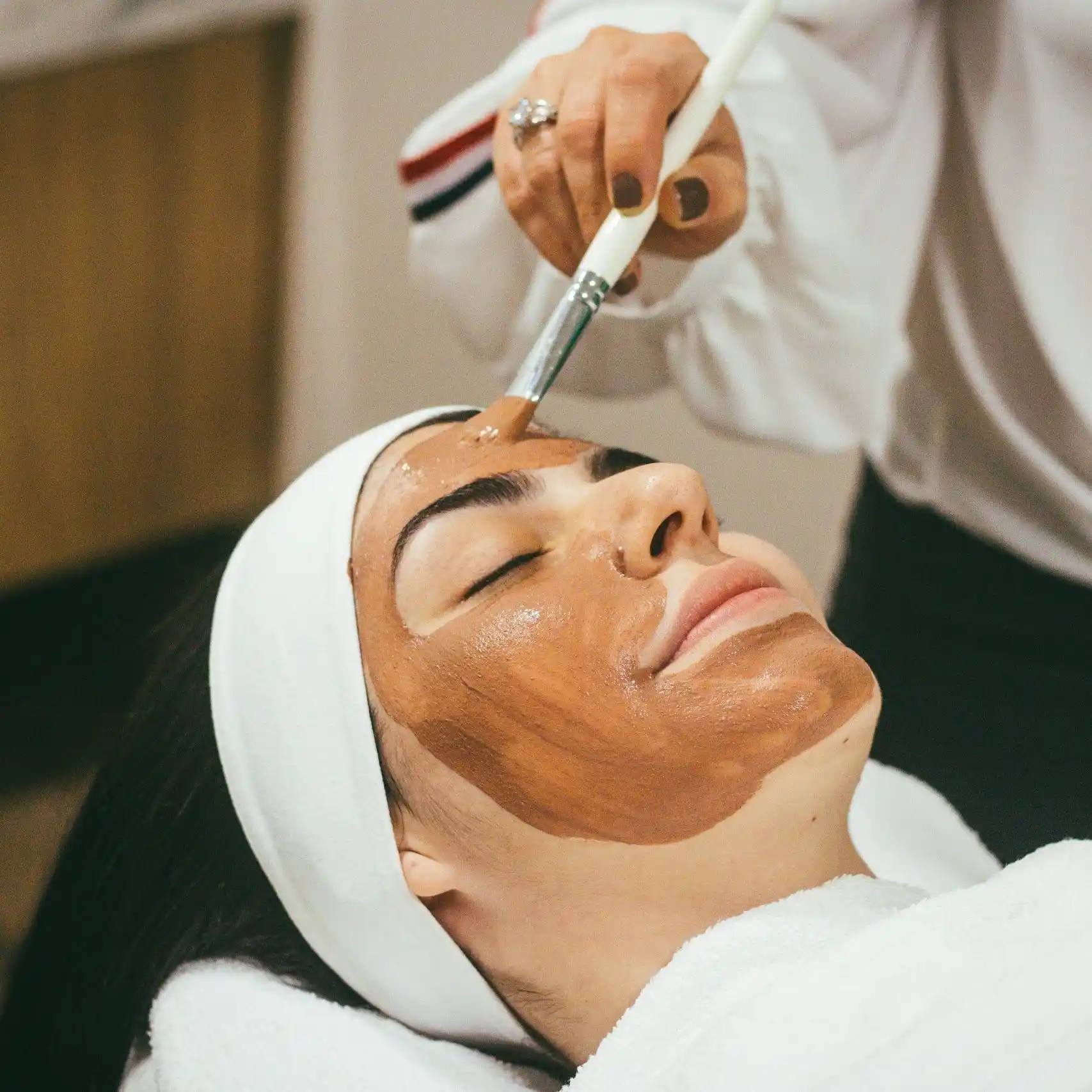 Relaxing facial treatment with rejuvenating face mask applied by professional