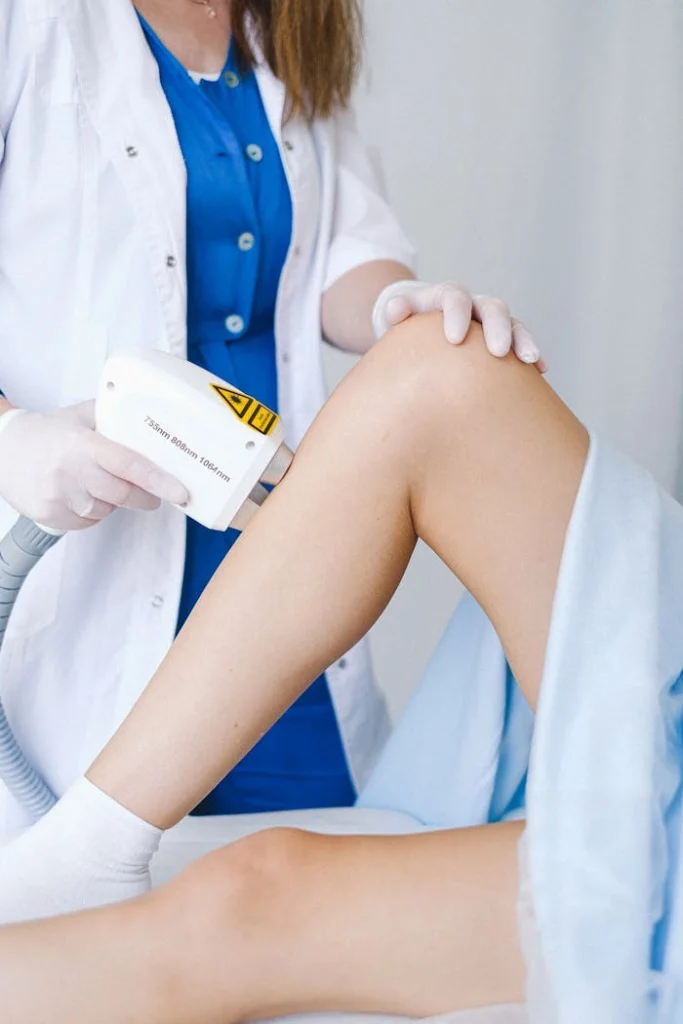 Laser hair removal treatment on lower leg by trained professional